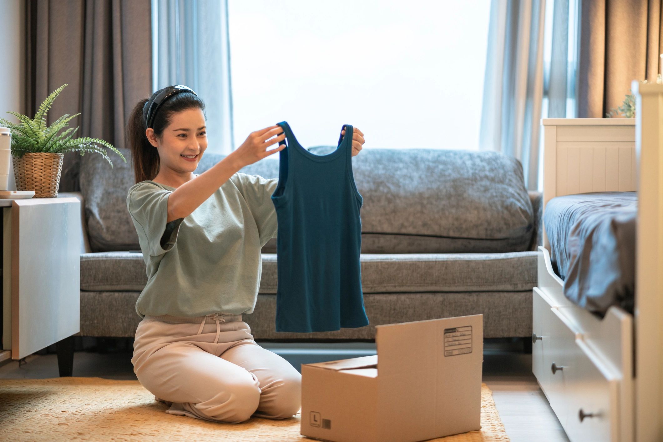 Woman sorting secondhand clothing for reuse at home